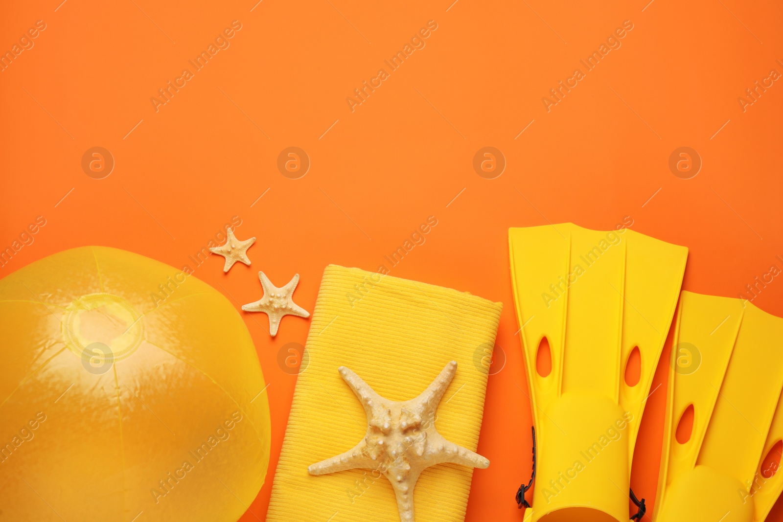 Photo of Flat lay composition with ball and beach objects on orange background, space for text