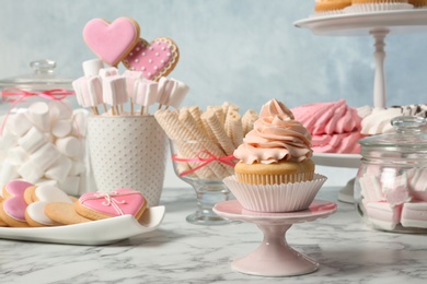 Photo of Candy bar with different sweets on white marble table against color background