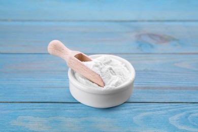 Photo of Bowl of fructose powder on light blue wooden table
