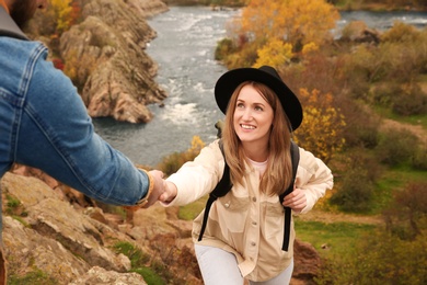 Couple of hikers with backpacks climbing up mountains