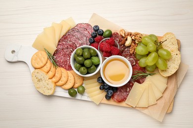 Photo of Snack set with delicious Parmesan cheese on light wooden table, top view