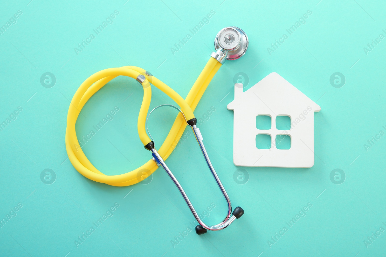 Photo of Flat lay composition with house model and stethoscope on color background, top view