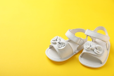 Photo of Pair of cute baby sandals on color background