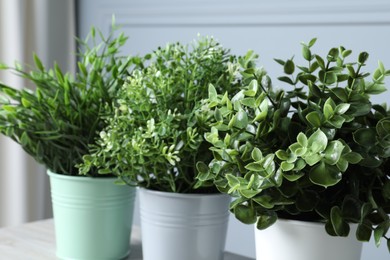 Photo of Different aromatic potted herbs on table, closeup
