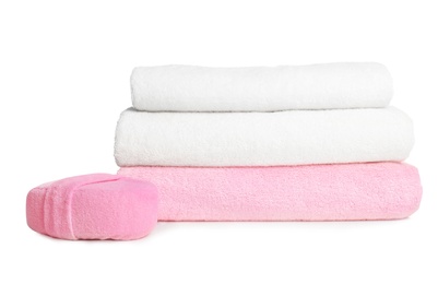 Folded soft terry towels and sponge on white background