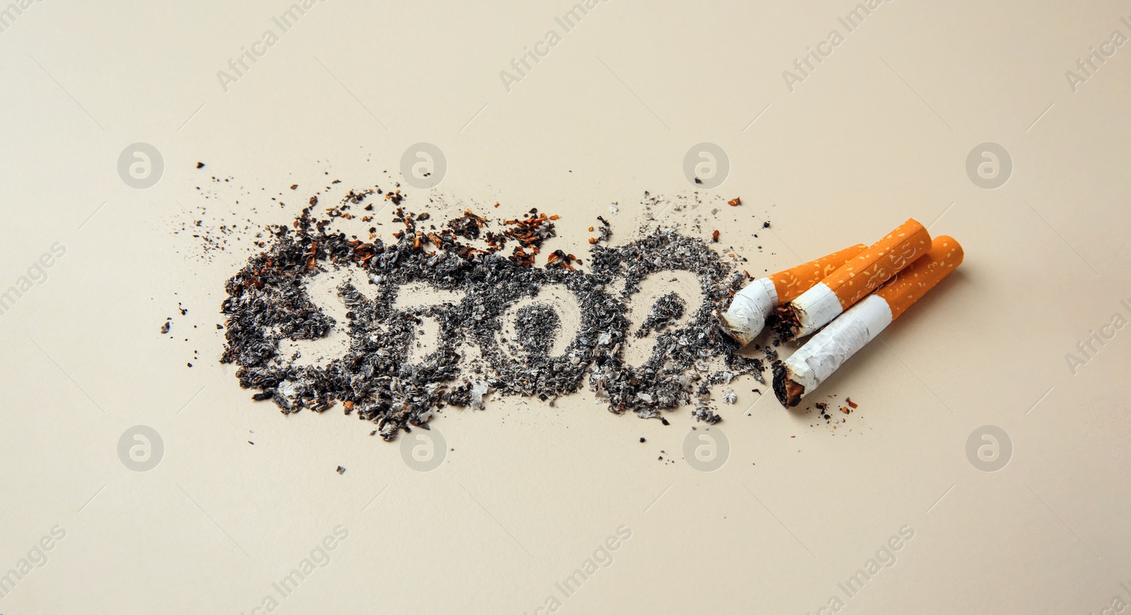 Photo of Word Stop made of cigarette ash and stubs on beige background. Quitting smoking concept