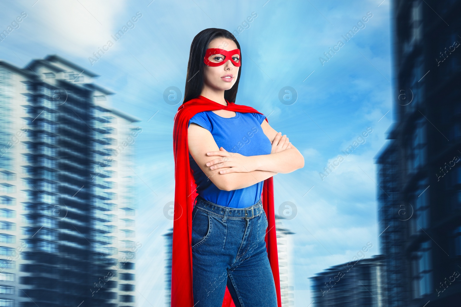 Image of Confident young woman wearing superhero costume and beautiful cityscape on background