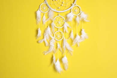 Photo of Beautiful dream catcher hanging on yellow background