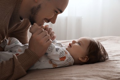 Photo of Father playing with his daughter at home