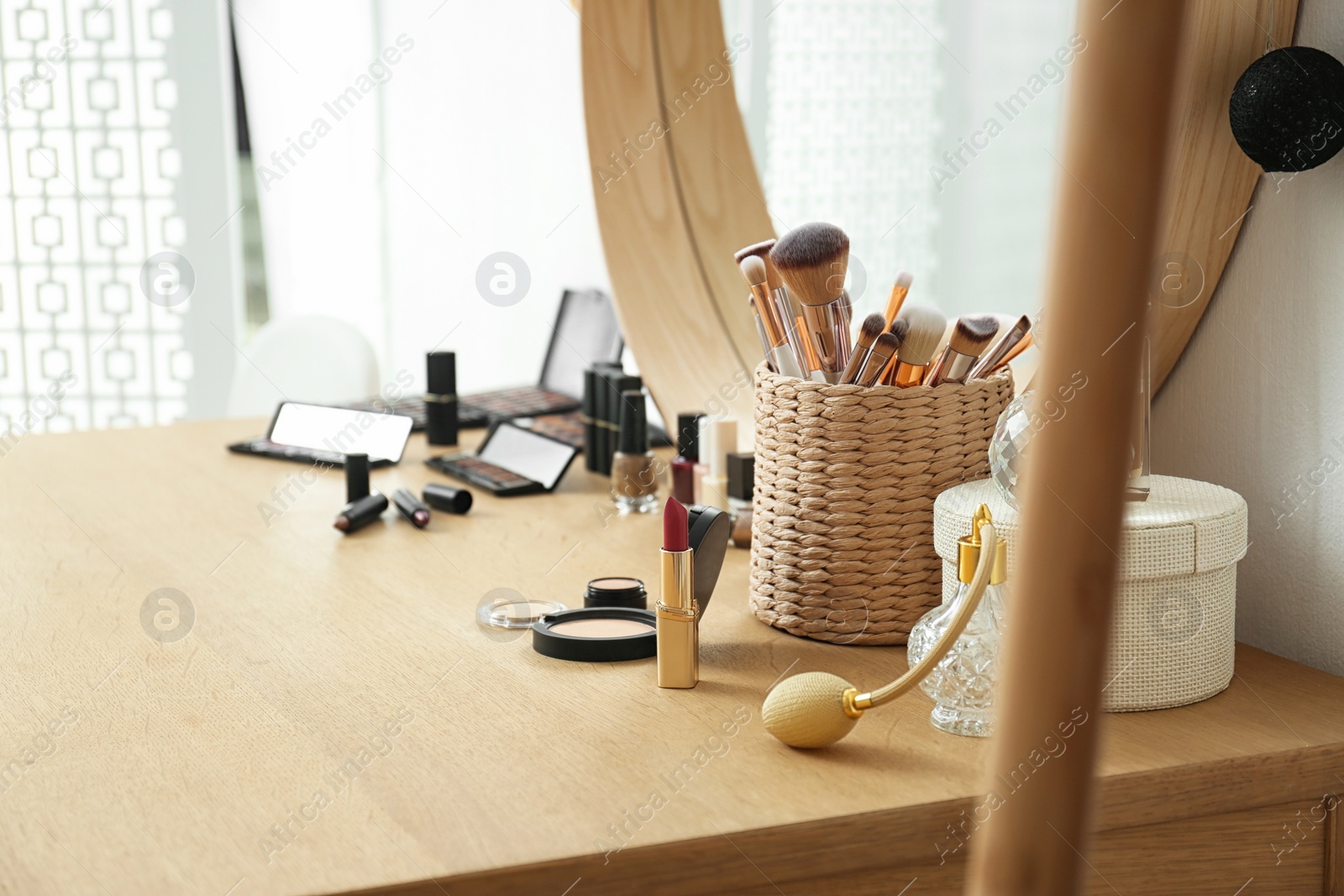 Photo of Cosmetics and brushes on dressing table in makeup room