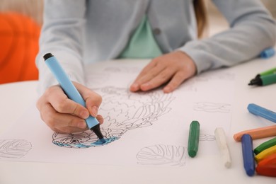 Photo of Child coloring drawing at table in room, closeup