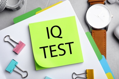 Image of Sticky note with text IQ Test and stationery on table, flat lay