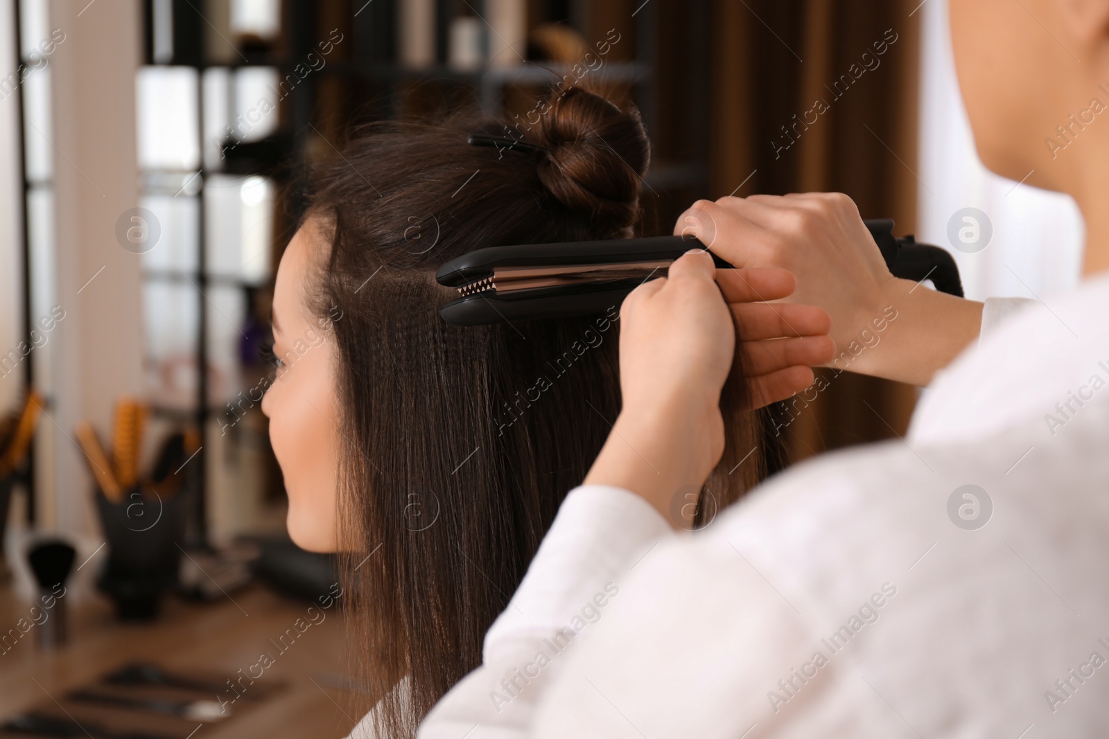 Photo of Stylist working with client in salon, making hairstyle