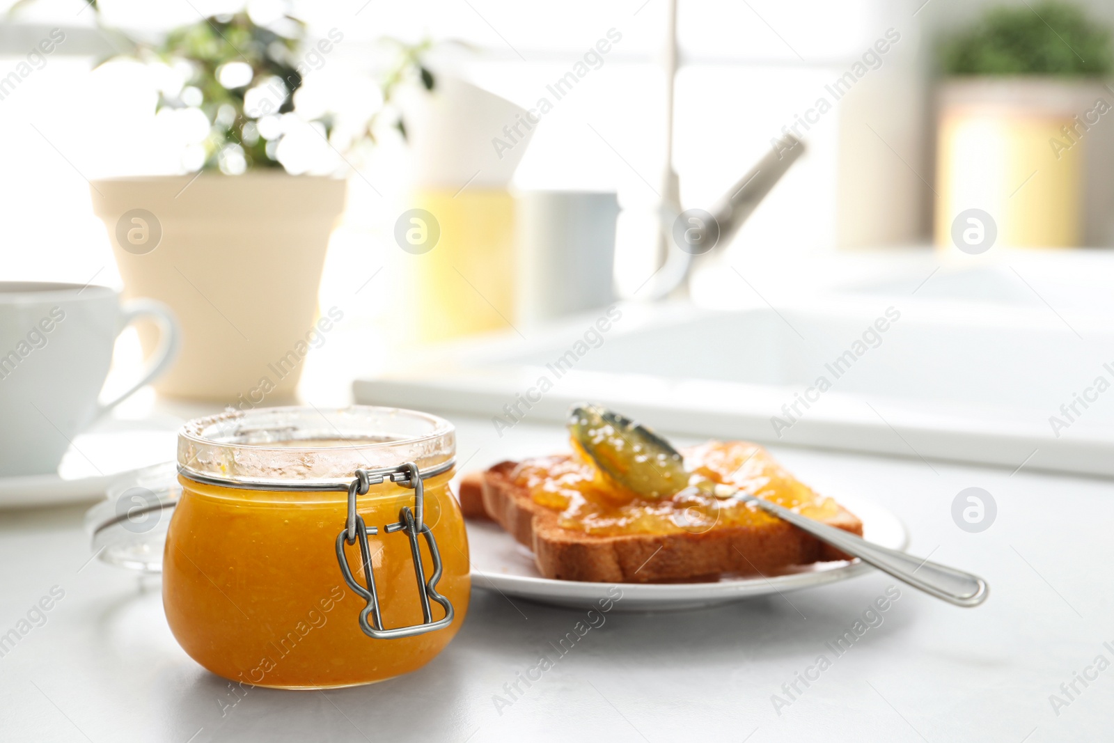 Photo of Delicious orange marmalade and toasts on white table. Space for text