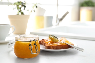 Photo of Delicious orange marmalade and toasts on white table. Space for text