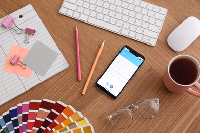 Photo of Smartphone on wooden table, above view. Designer's workplace