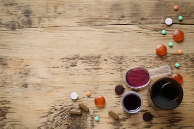 Photo of Flat lay composition with cough drops, syrup and pills on wooden background. Space for text