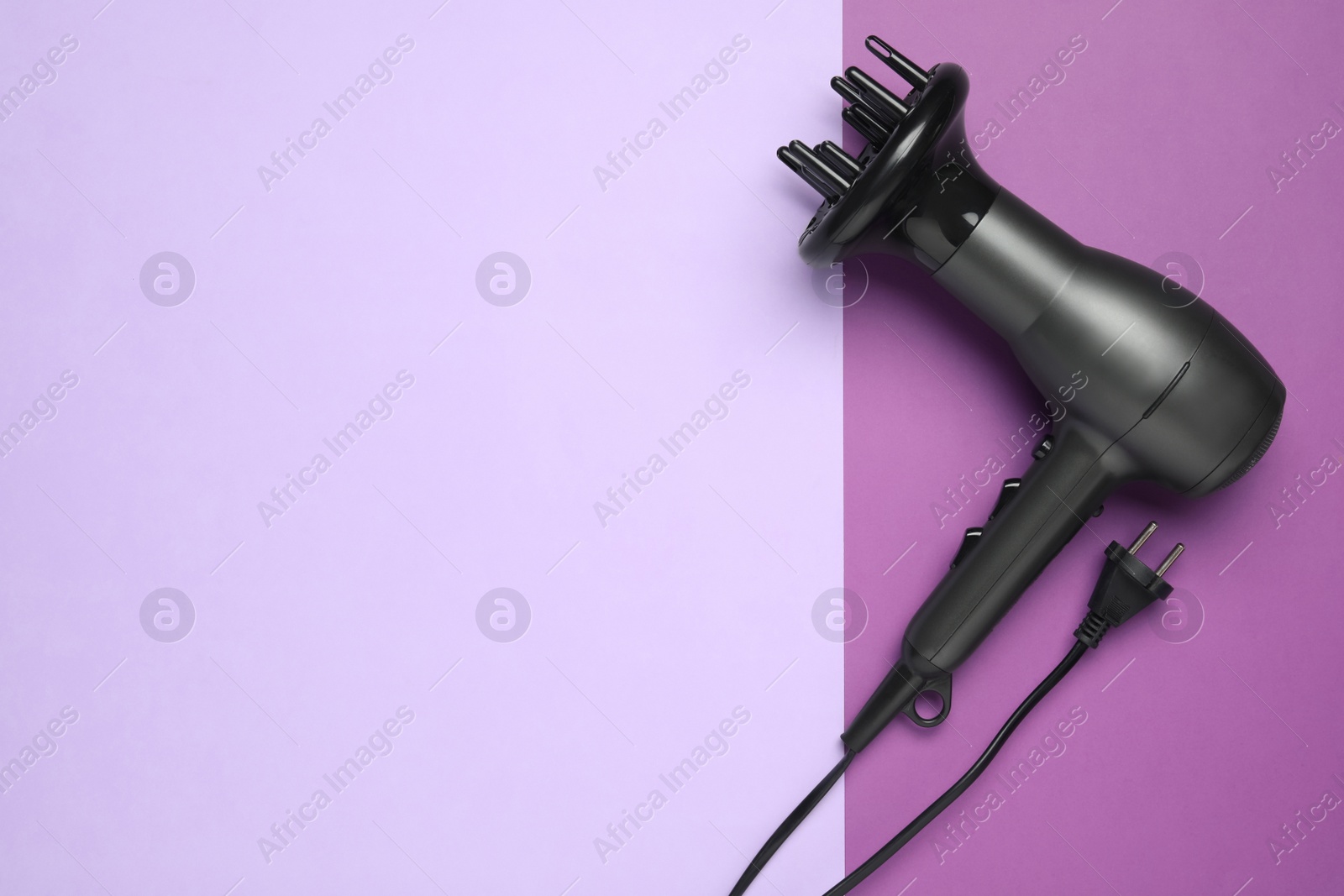 Photo of Hair dryer on color background, top view with space for text. Professional hairdresser tool