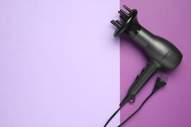 Photo of Hair dryer on color background, top view with space for text. Professional hairdresser tool