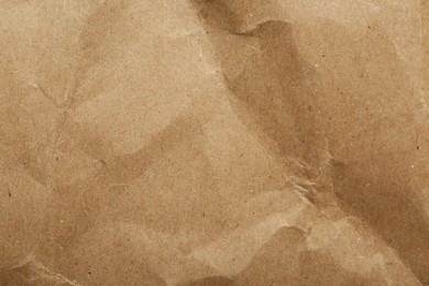 Photo of Crumpled kraft notebook sheet as background, top view