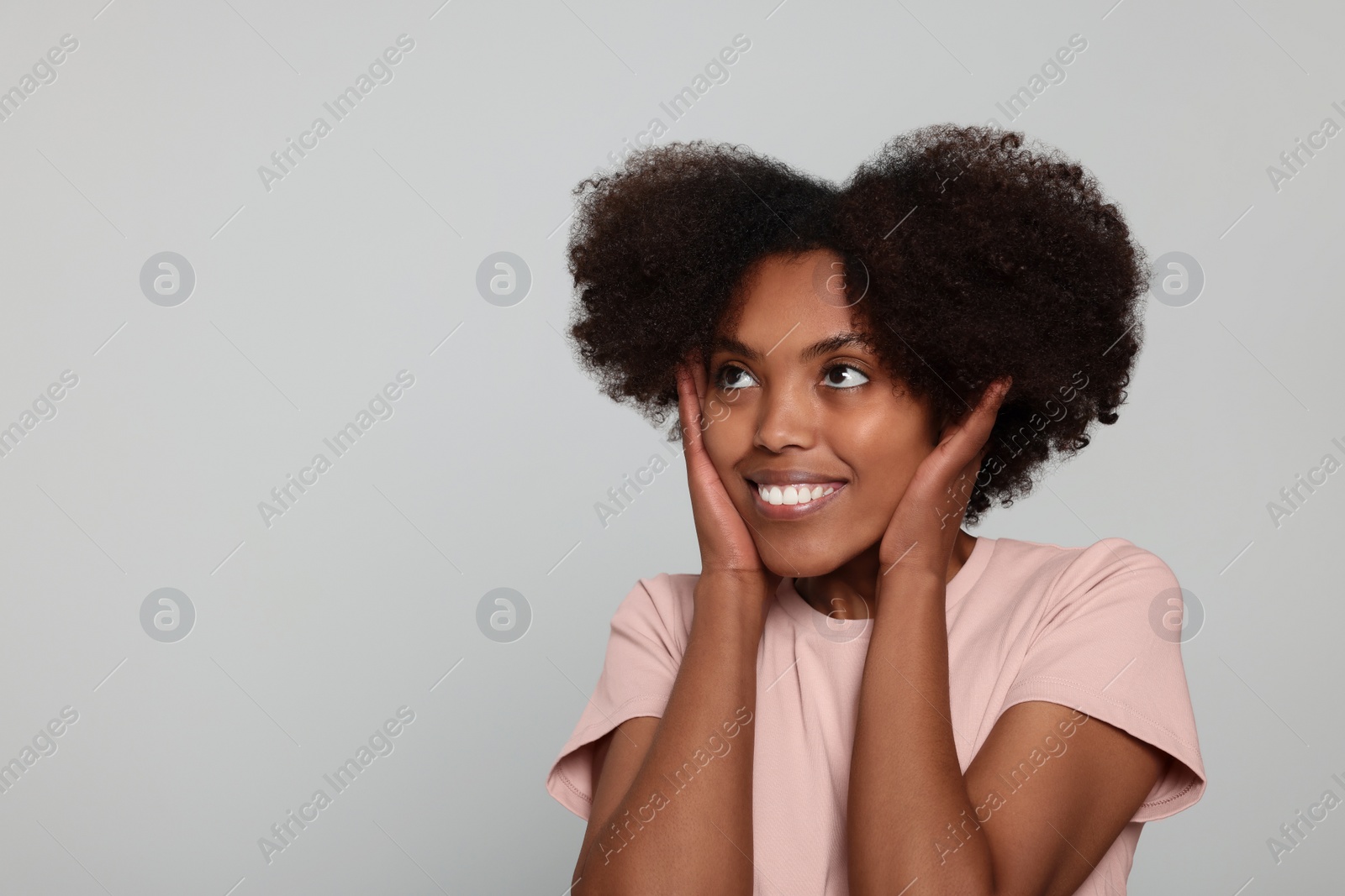 Photo of Portrait of smiling African American woman on light grey background. Space for text