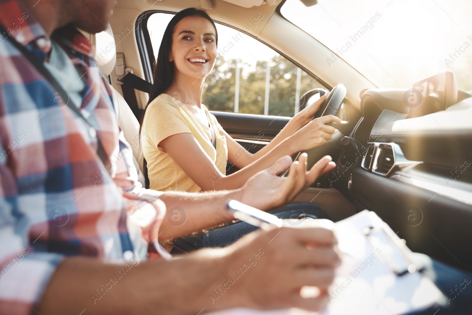 Photo of Young woman in car with instructor. Driving school