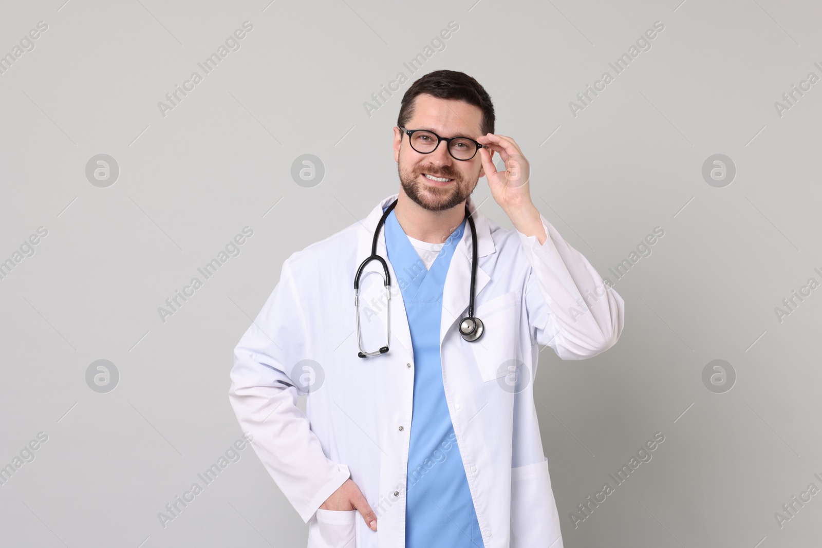 Photo of Portrait of smiling doctor on light grey background