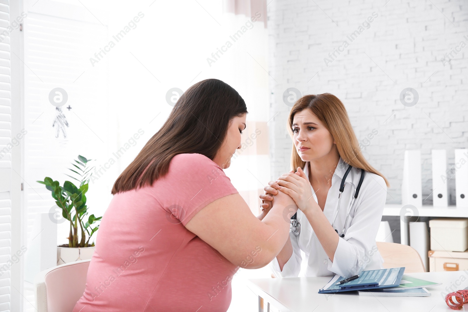 Photo of Female doctor consulting overweight woman in clinic