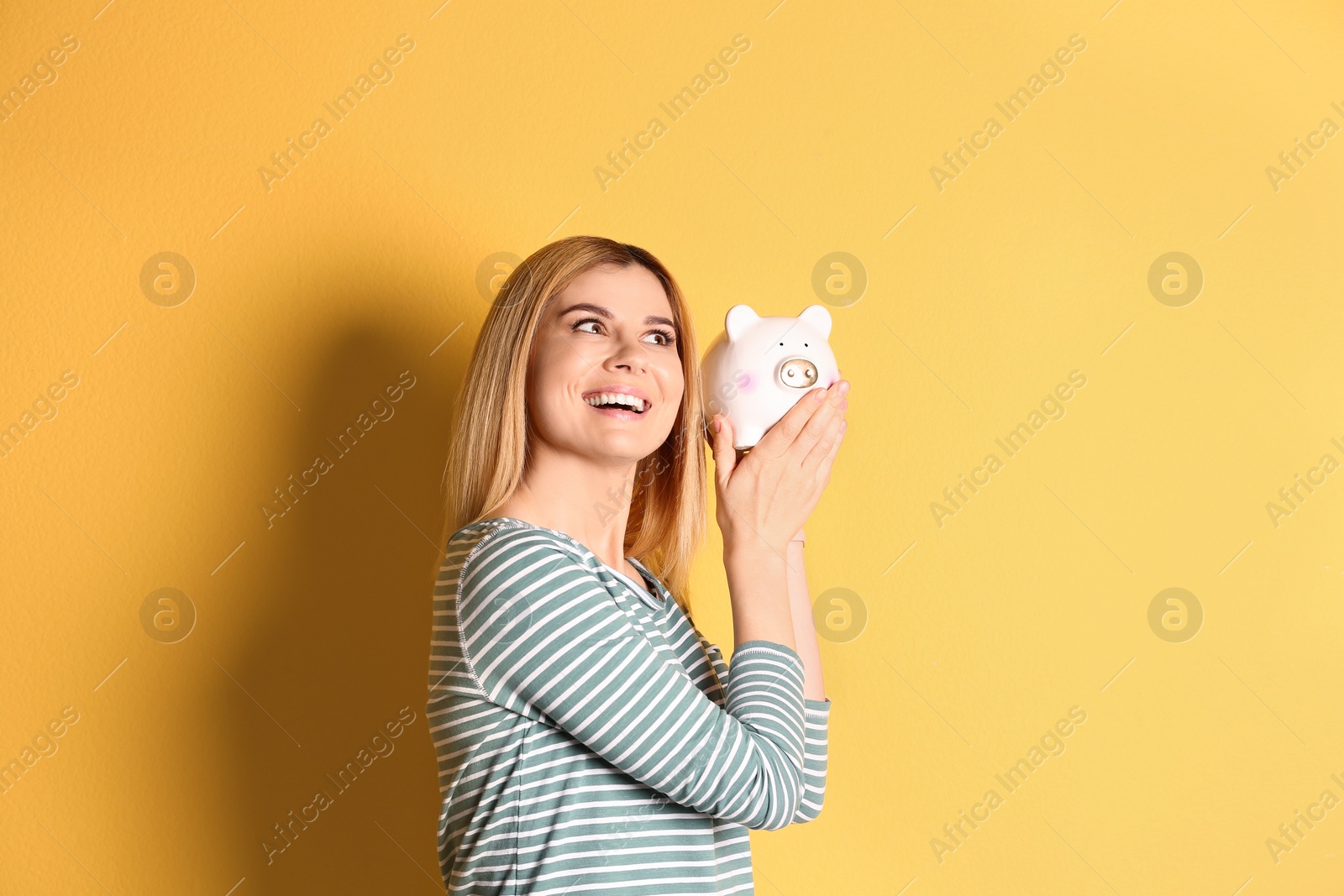 Photo of Woman with piggy bank on color background