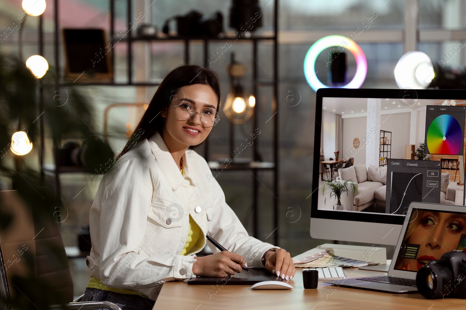 Photo of Professional retoucher working on computer and laptop in office