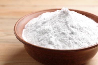 Bowl with baking soda on wooden table