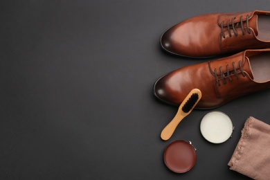 Flat lay composition with shoe care accessories and footwear on black background. Space for text
