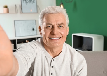 Photo of Mature man using video chat at home, view from web camera