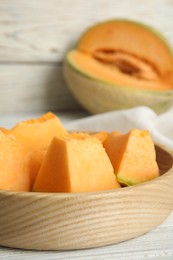 Photo of Pieces of tasty melon on white table, closeup