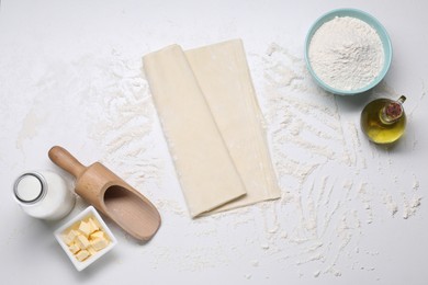 Photo of Fresh dough and different ingredients for making baklava on white table, flat lay