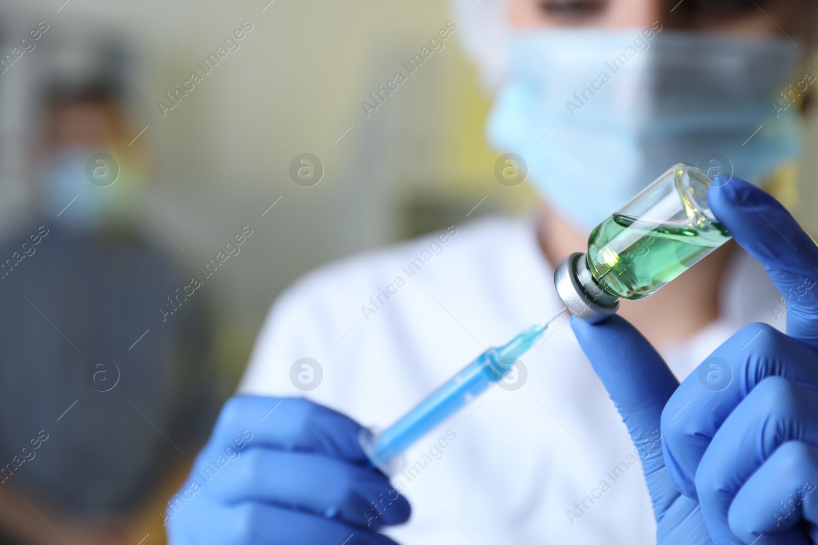 Photo of Doctor filling syringe with medication in clinic, focus on hands. Vaccination and immunization