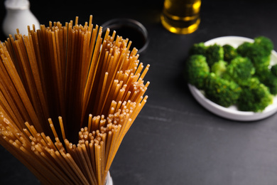 Photo of Uncooked buckwheat noodles on black table, closeup