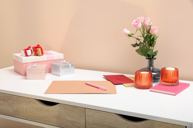 Greeting card, flowers and candles on white table indoors