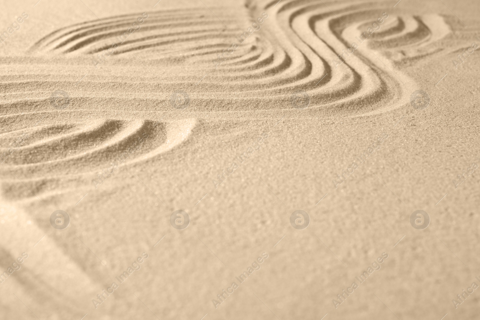 Photo of Beautiful lines drawn on sand, closeup with space for text. Zen garden