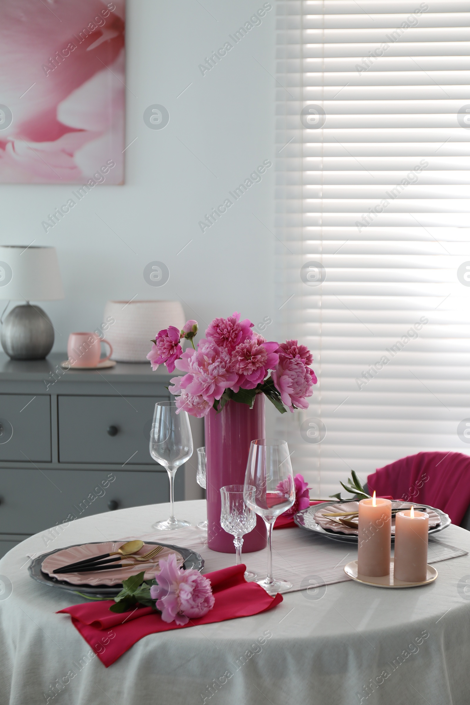 Photo of Beautiful table setting with pink peonies and burning candles