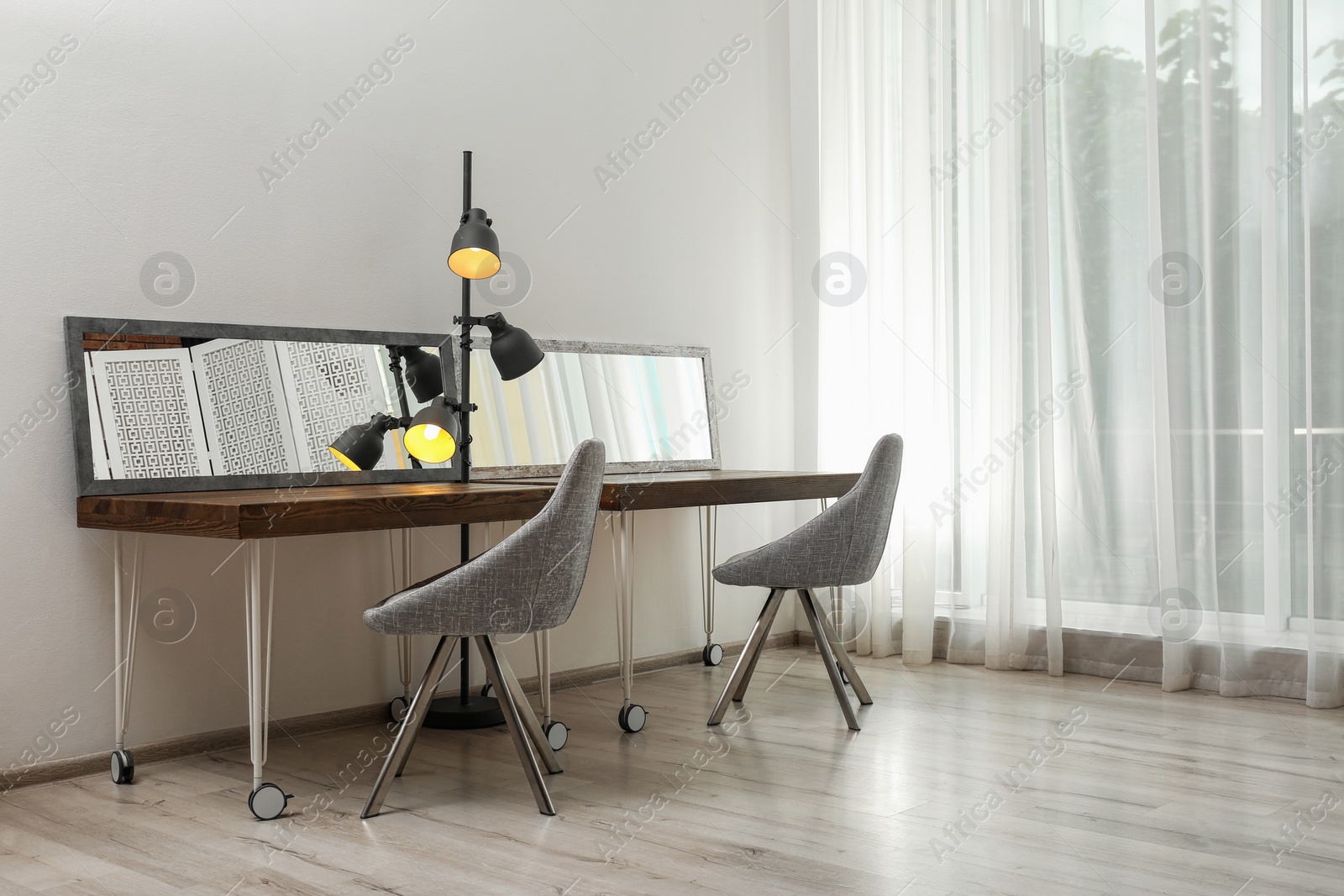 Photo of Empty dressing tables with mirrors in makeup room