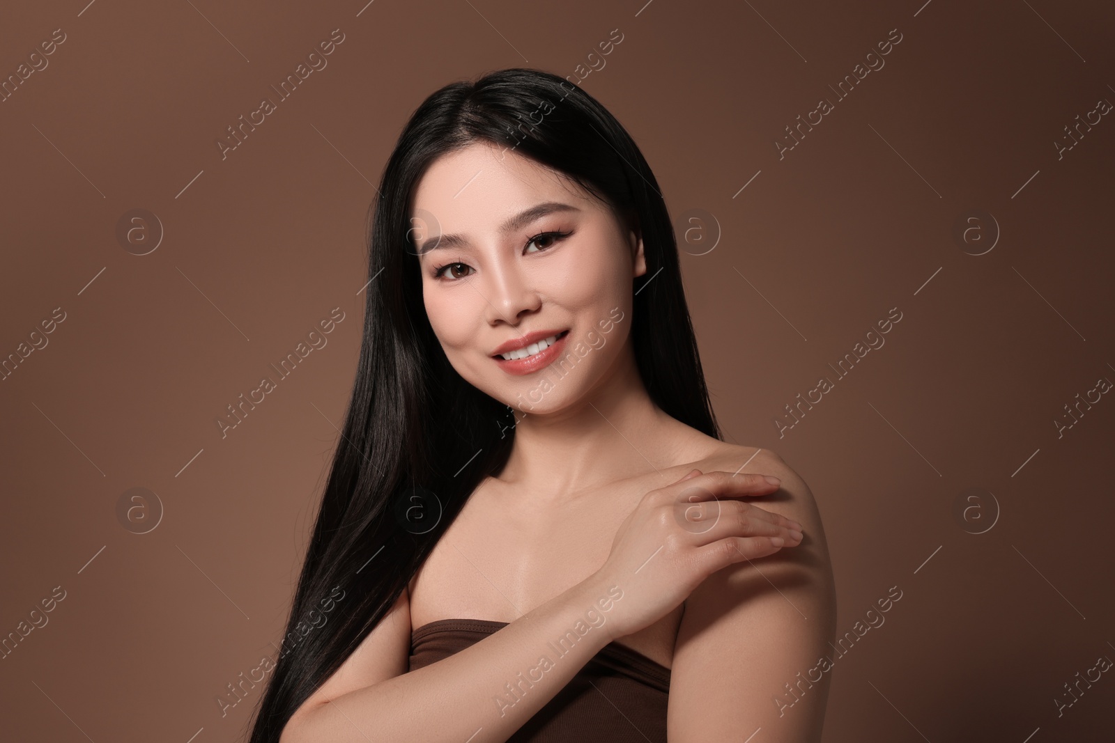 Photo of Portrait of beautiful woman on brown background