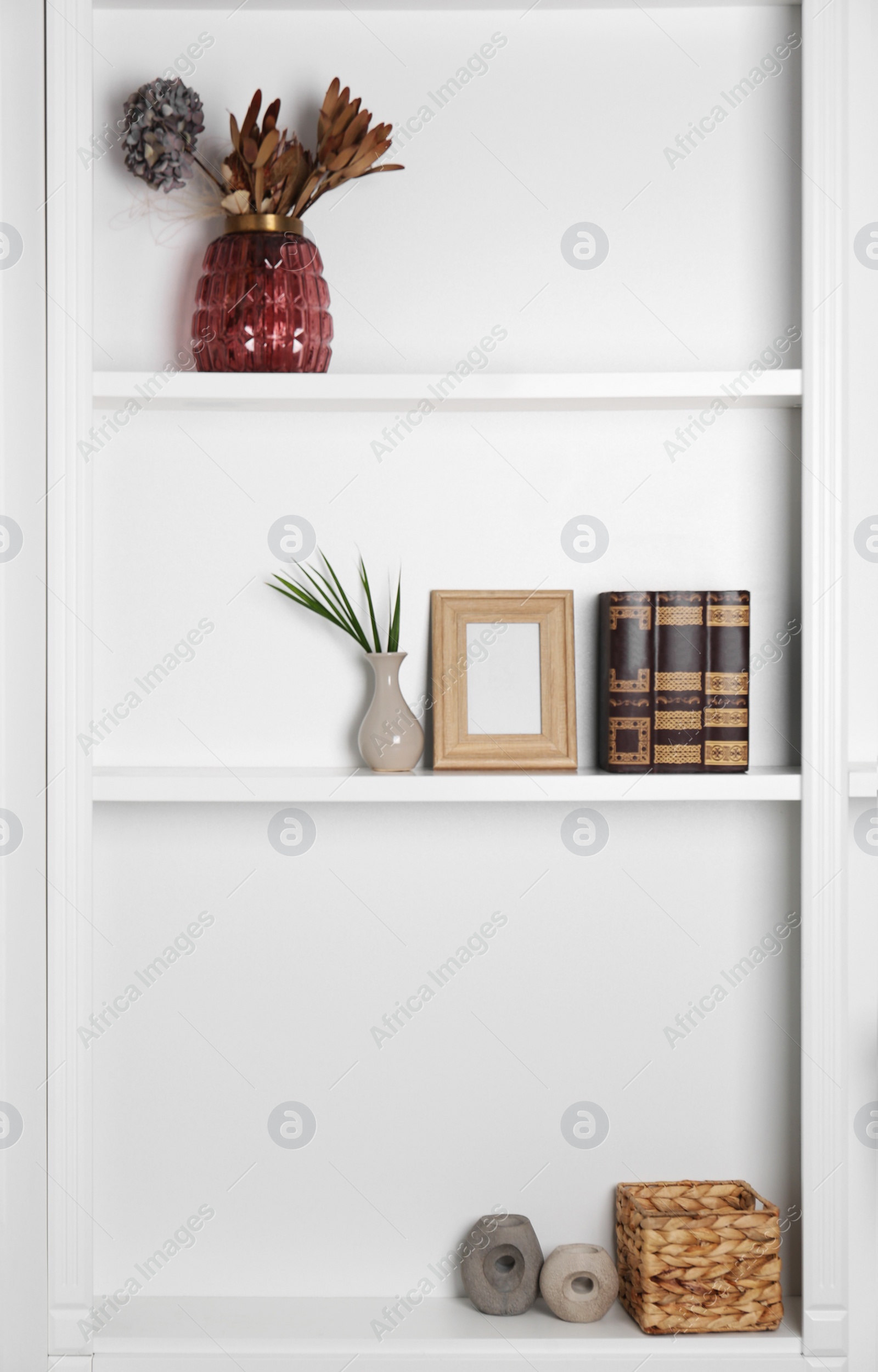 Photo of White shelving unit with different decor elements. Interior design