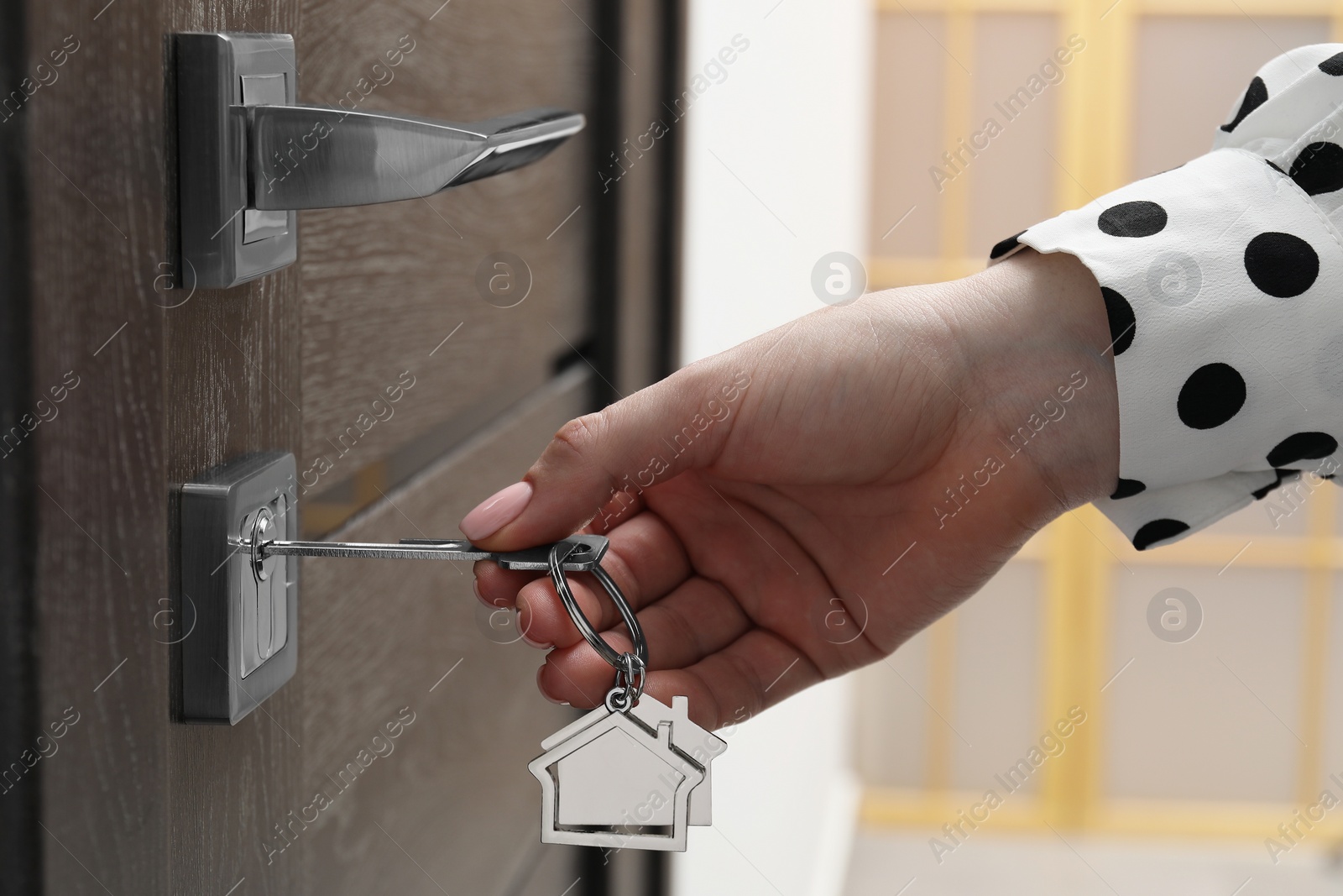 Photo of Woman unlocking door with key, closeup view