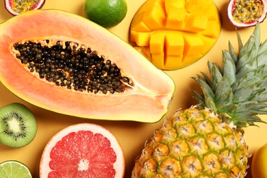 Photo of Fresh ripe papaya and other fruits on yellow background. flat lay