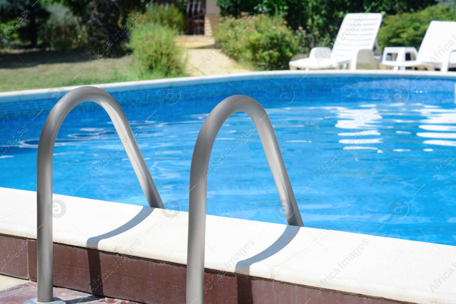 Photo of Swimming pool with metal ladder on sunny day