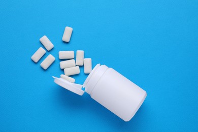 Photo of Jar with chewing gums on light blue background, flat lay