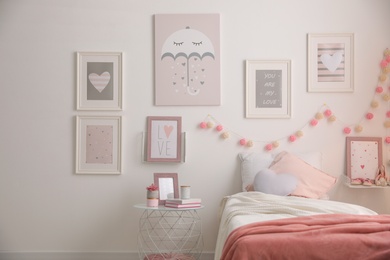 Photo of Stylish child's room interior with beautiful pictures and comfortable bed