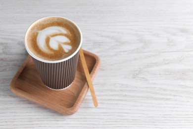 Coffee to go. Paper cup with tasty drink on white wooden table, space for text