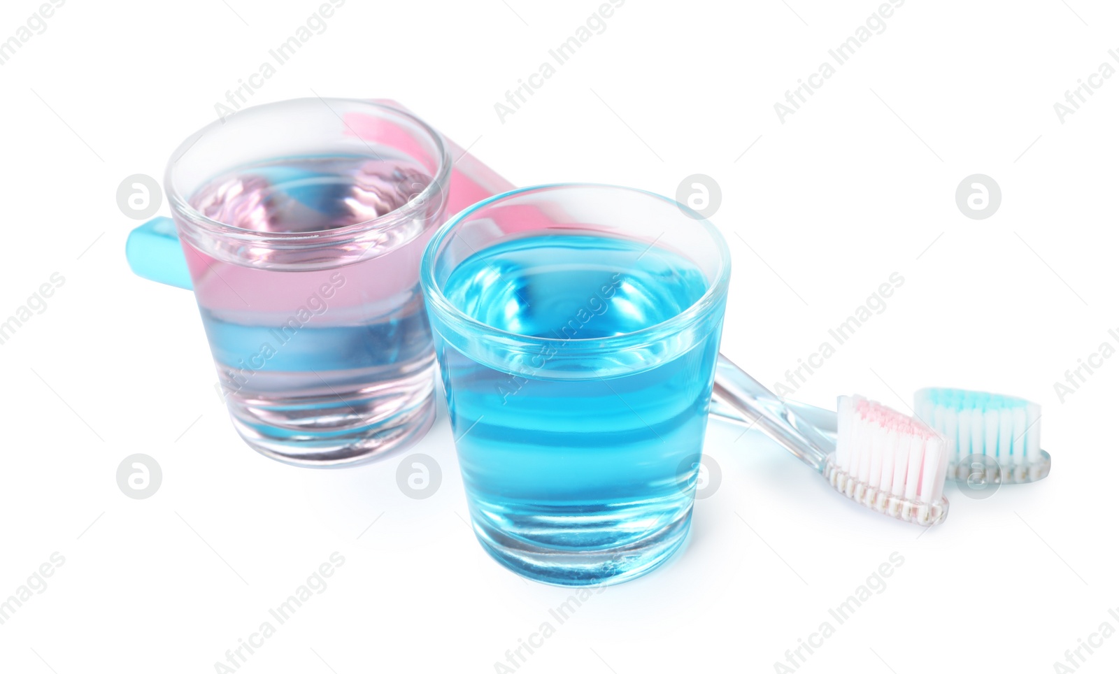 Photo of Glasses with mouthwash and toothbrushes on white background. Teeth hygiene